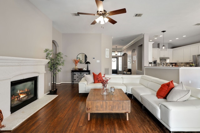 living room with ceiling fan, dark hardwood / wood-style flooring, and crown molding