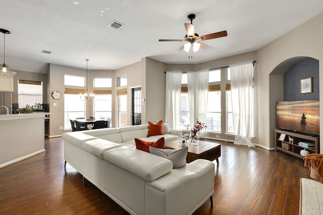 living room featuring ceiling fan with notable chandelier and dark hardwood / wood-style floors