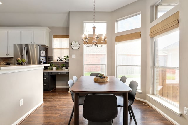 dining space featuring a chandelier, dark hardwood / wood-style flooring, and a healthy amount of sunlight