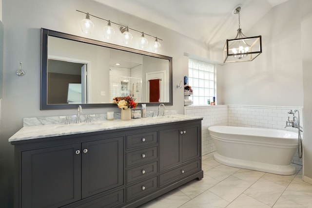 bathroom featuring plus walk in shower, vanity, and a notable chandelier