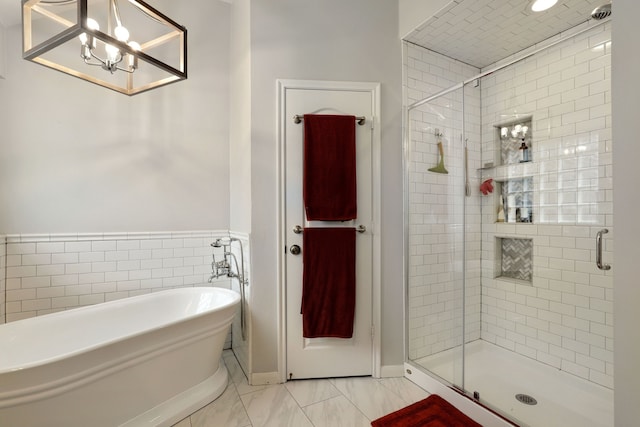 bathroom featuring tile patterned flooring, shower with separate bathtub, and a notable chandelier