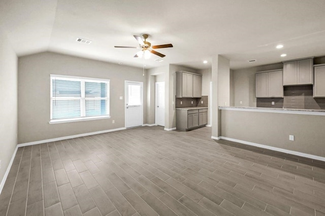 unfurnished living room with ceiling fan and lofted ceiling