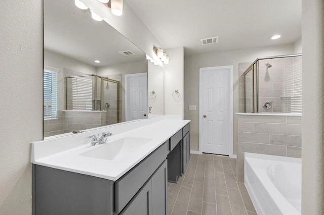 bathroom with vanity and shower with separate bathtub