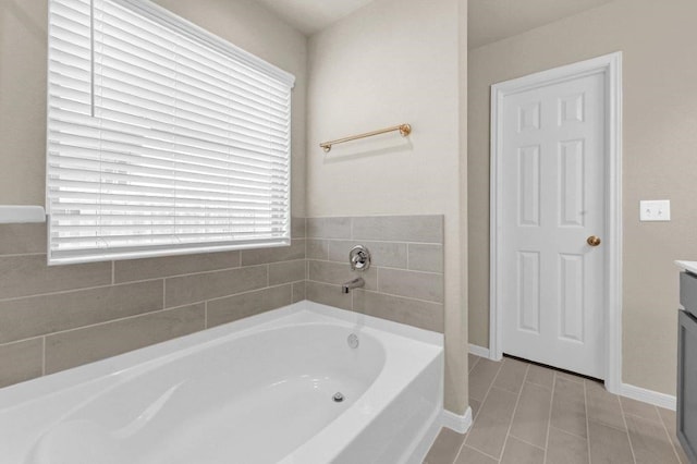 bathroom with tile patterned flooring, vanity, and a washtub