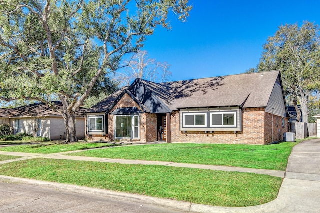 tudor-style house with a front lawn and cooling unit