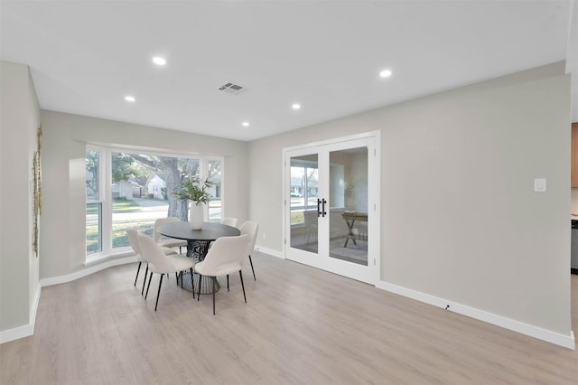 dining area featuring light wood-type flooring and french doors