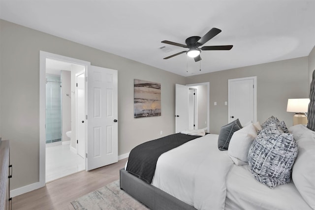 bedroom with ceiling fan, ensuite bathroom, and light hardwood / wood-style flooring