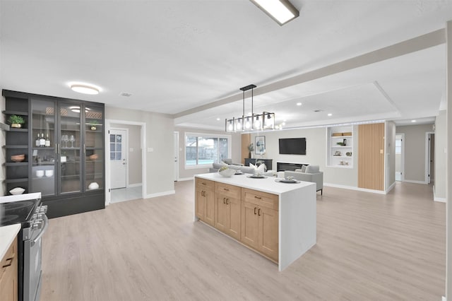 kitchen with light hardwood / wood-style floors, stainless steel electric range oven, light brown cabinets, a kitchen island, and pendant lighting