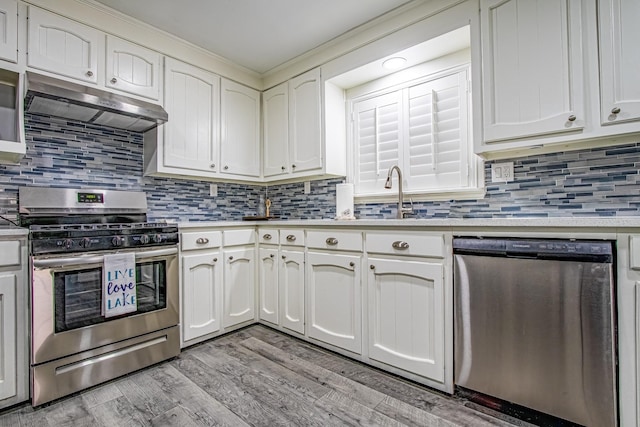 kitchen featuring decorative backsplash, light wood-type flooring, white cabinetry, and appliances with stainless steel finishes