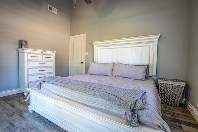 bedroom with dark hardwood / wood-style flooring and ceiling fan