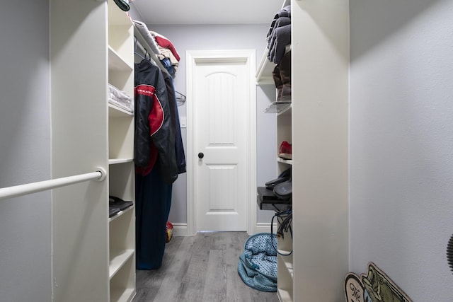 walk in closet with light hardwood / wood-style floors