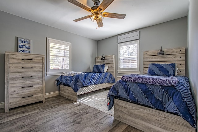 bedroom featuring multiple windows, ceiling fan, and hardwood / wood-style flooring