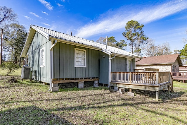 exterior space featuring cooling unit, a yard, and a wooden deck