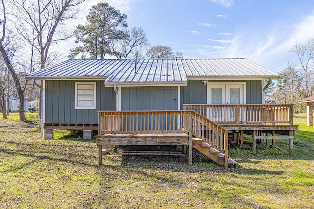 view of front of house with a wooden deck, french doors, and a front lawn