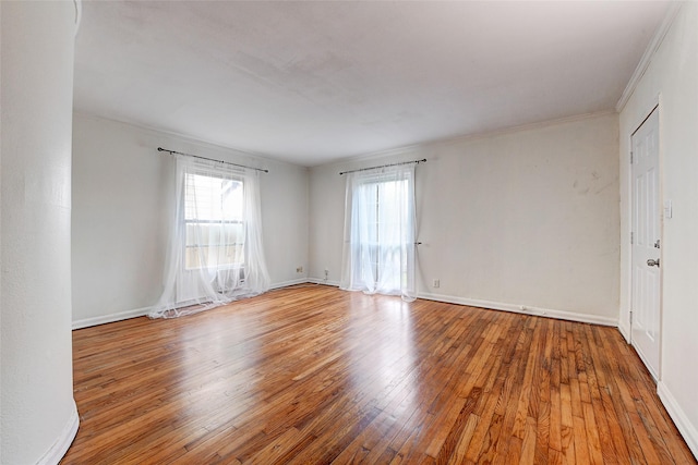 empty room featuring ornamental molding and hardwood / wood-style flooring