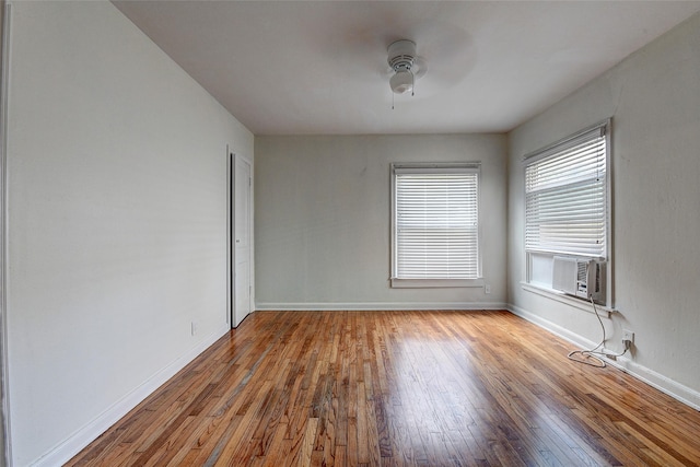 empty room featuring ceiling fan, hardwood / wood-style floors, and cooling unit