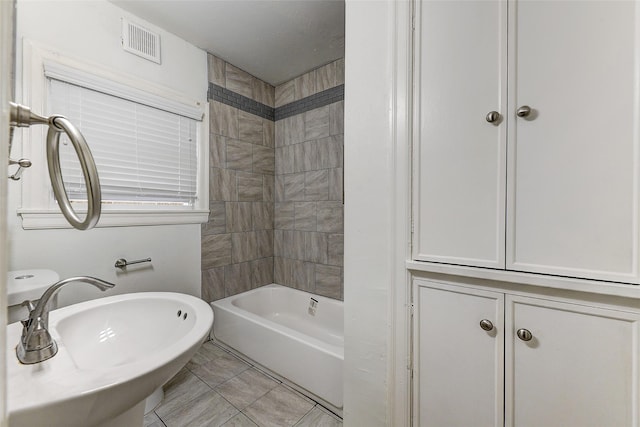 bathroom featuring tiled shower / bath combo, tile patterned floors, and sink