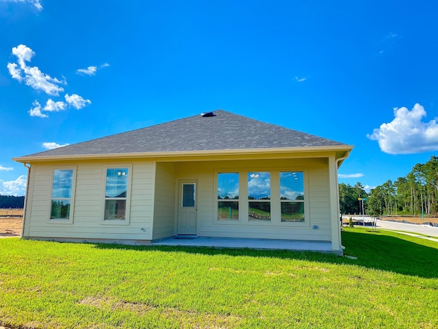 back of property featuring a lawn