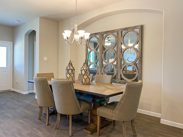 dining space featuring dark wood-type flooring and an inviting chandelier