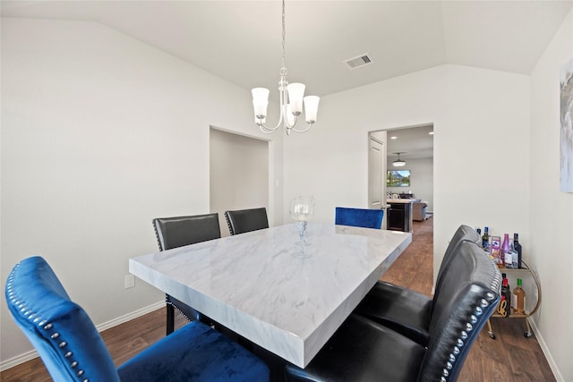 dining room featuring a chandelier, dark wood-type flooring, and vaulted ceiling