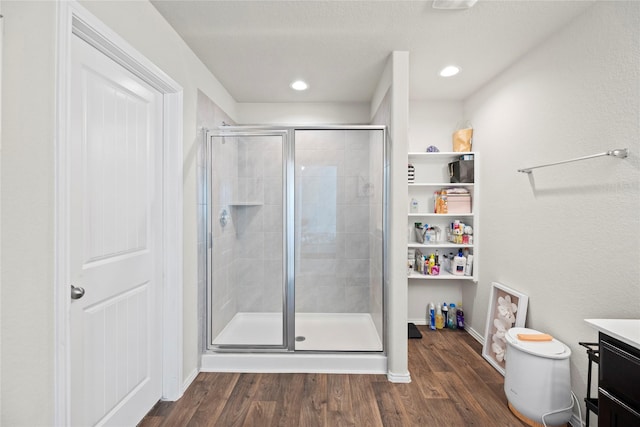 bathroom featuring hardwood / wood-style floors, vanity, an enclosed shower, and toilet