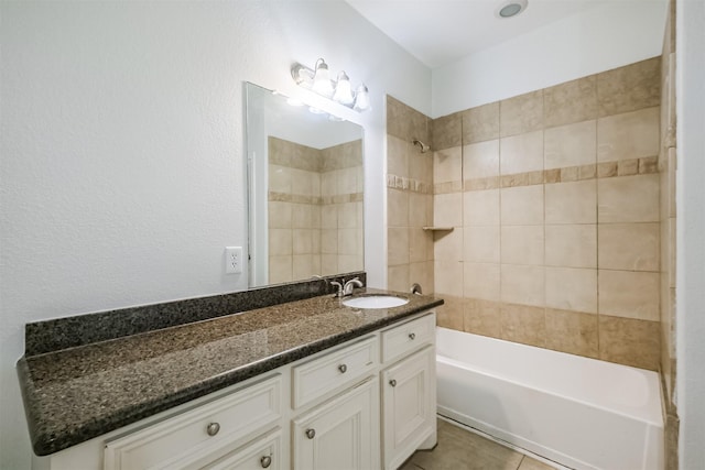 bathroom with tile patterned flooring, vanity, and tiled shower / bath