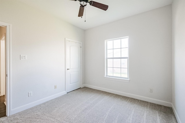 carpeted spare room featuring ceiling fan