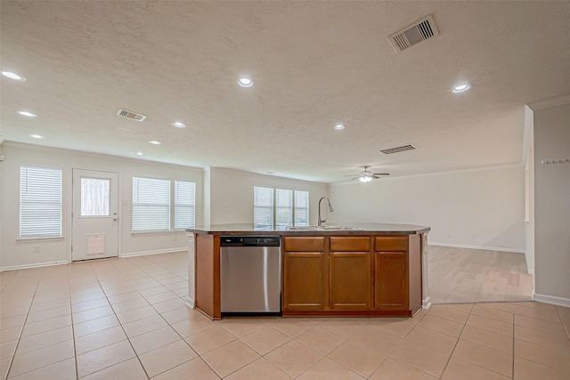 kitchen featuring dishwasher, ceiling fan, sink, and a kitchen island with sink