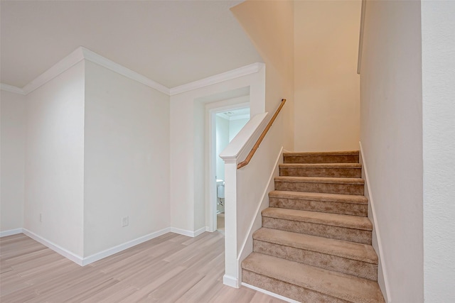 staircase featuring hardwood / wood-style flooring and crown molding