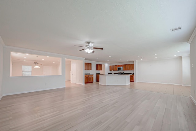 unfurnished living room with ceiling fan, ornamental molding, and light wood-type flooring