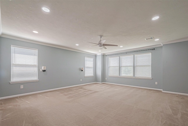 carpeted spare room with ceiling fan and ornamental molding