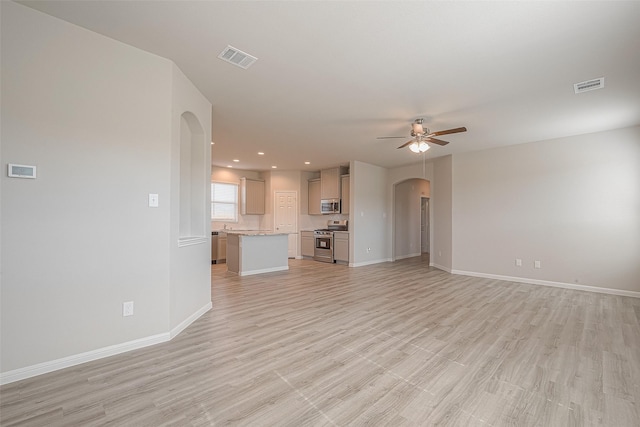 unfurnished living room featuring ceiling fan and light hardwood / wood-style floors