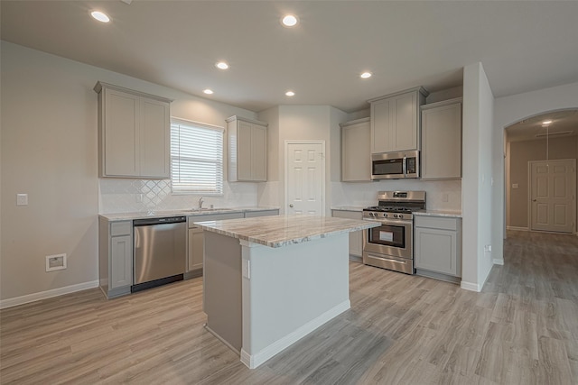 kitchen featuring gray cabinetry, a center island, light wood-type flooring, and appliances with stainless steel finishes