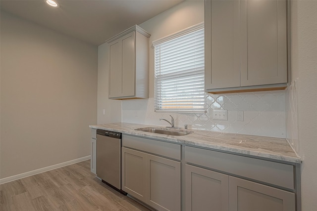 kitchen featuring dishwasher, light stone countertops, gray cabinetry, and sink