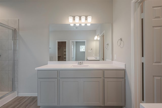 bathroom featuring vanity, an enclosed shower, and wood-type flooring