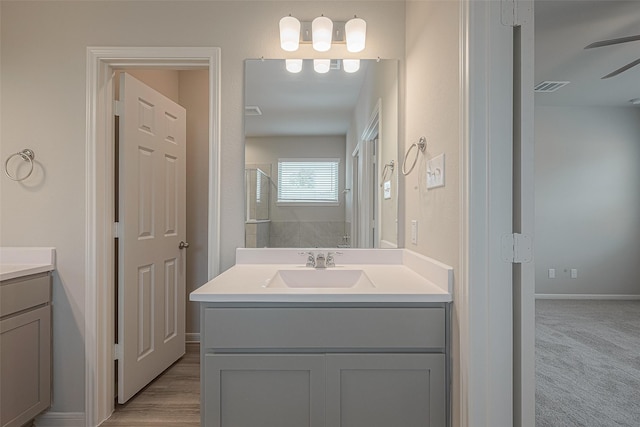 bathroom with ceiling fan, a shower, and vanity