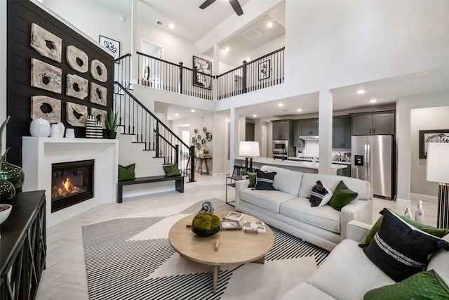 living room with ceiling fan and a high ceiling