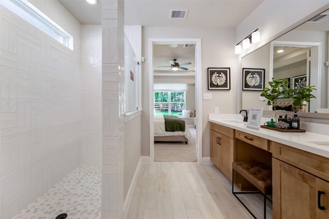 bathroom with a shower, hardwood / wood-style floors, vanity, and ceiling fan