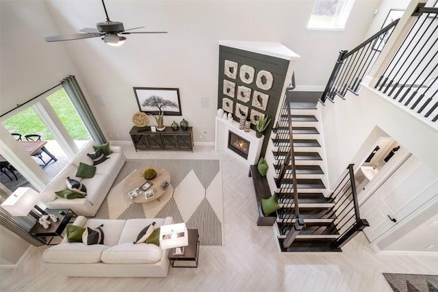 living room featuring stairs, a large fireplace, and a high ceiling