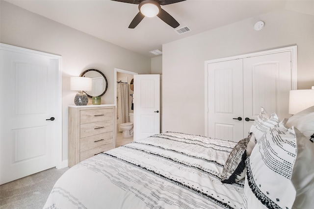 bedroom with visible vents, a ceiling fan, light colored carpet, ensuite bath, and a closet