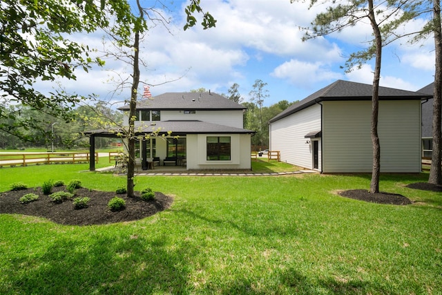 back of house with a yard, a shingled roof, a patio area, and fence