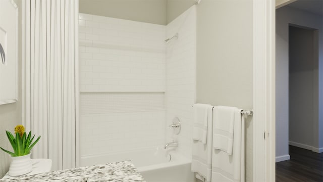 bathroom with hardwood / wood-style flooring and shower / bath combination