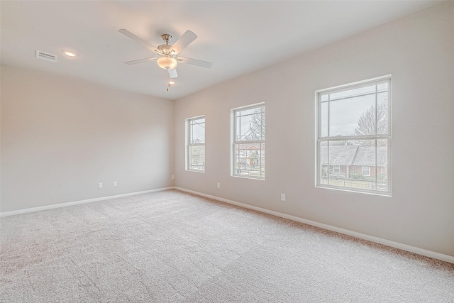 carpeted spare room featuring ceiling fan