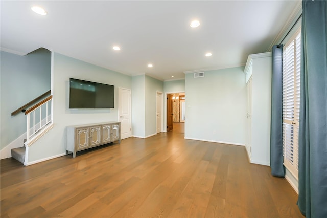 unfurnished living room featuring dark hardwood / wood-style flooring and ornamental molding