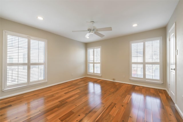 unfurnished room featuring hardwood / wood-style flooring, ceiling fan, and a healthy amount of sunlight