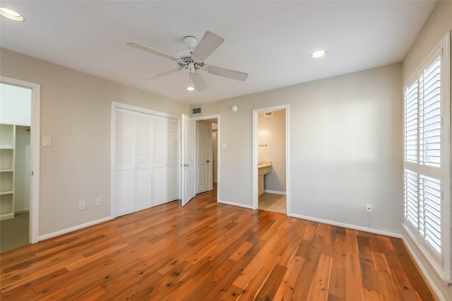 unfurnished bedroom with ensuite bath, ceiling fan, and hardwood / wood-style flooring