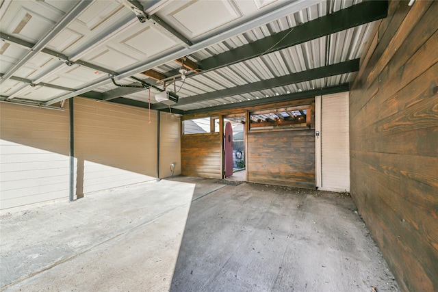 garage featuring wooden walls and a garage door opener