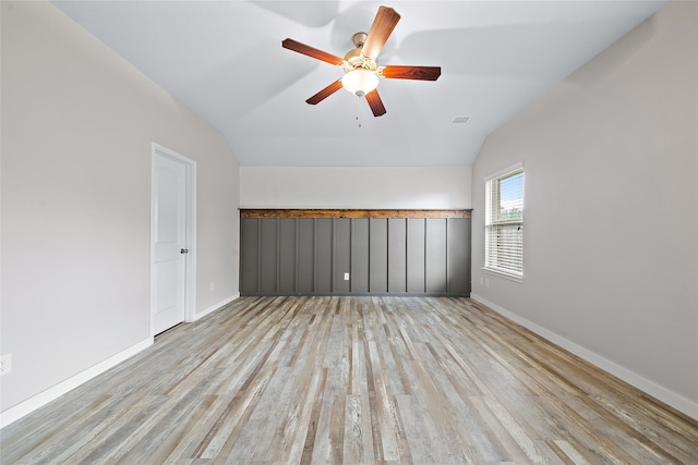 additional living space with ceiling fan, vaulted ceiling, and light wood-type flooring