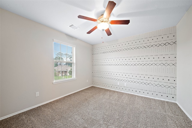 carpeted spare room featuring ceiling fan