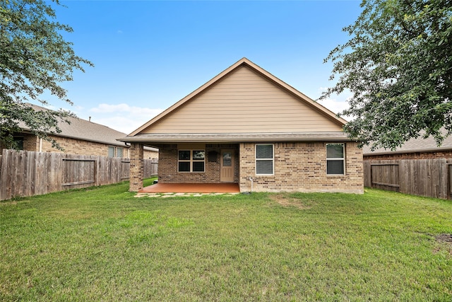 rear view of house featuring a lawn and a patio area